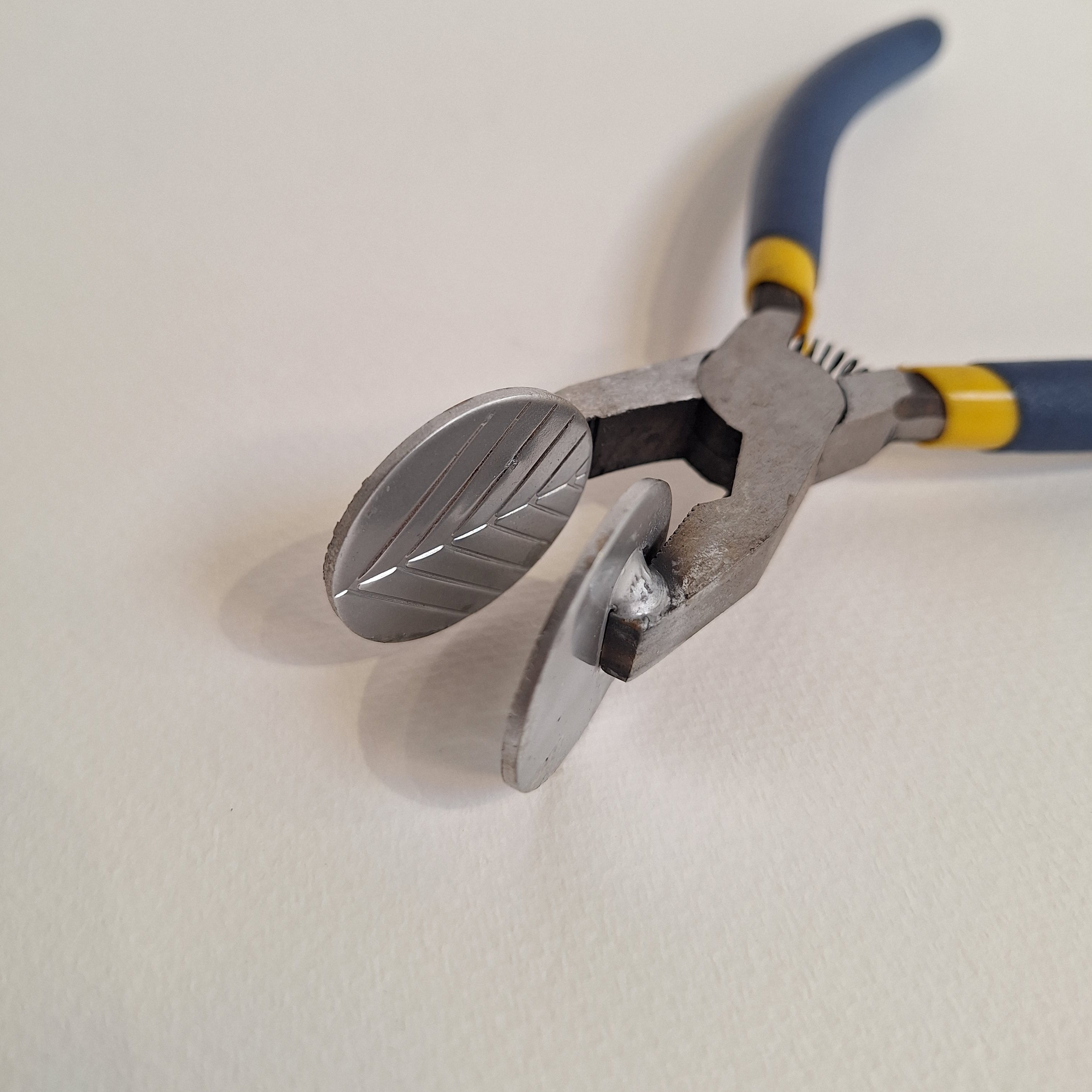 Pair of lampworking mashers with blue handles on a white background