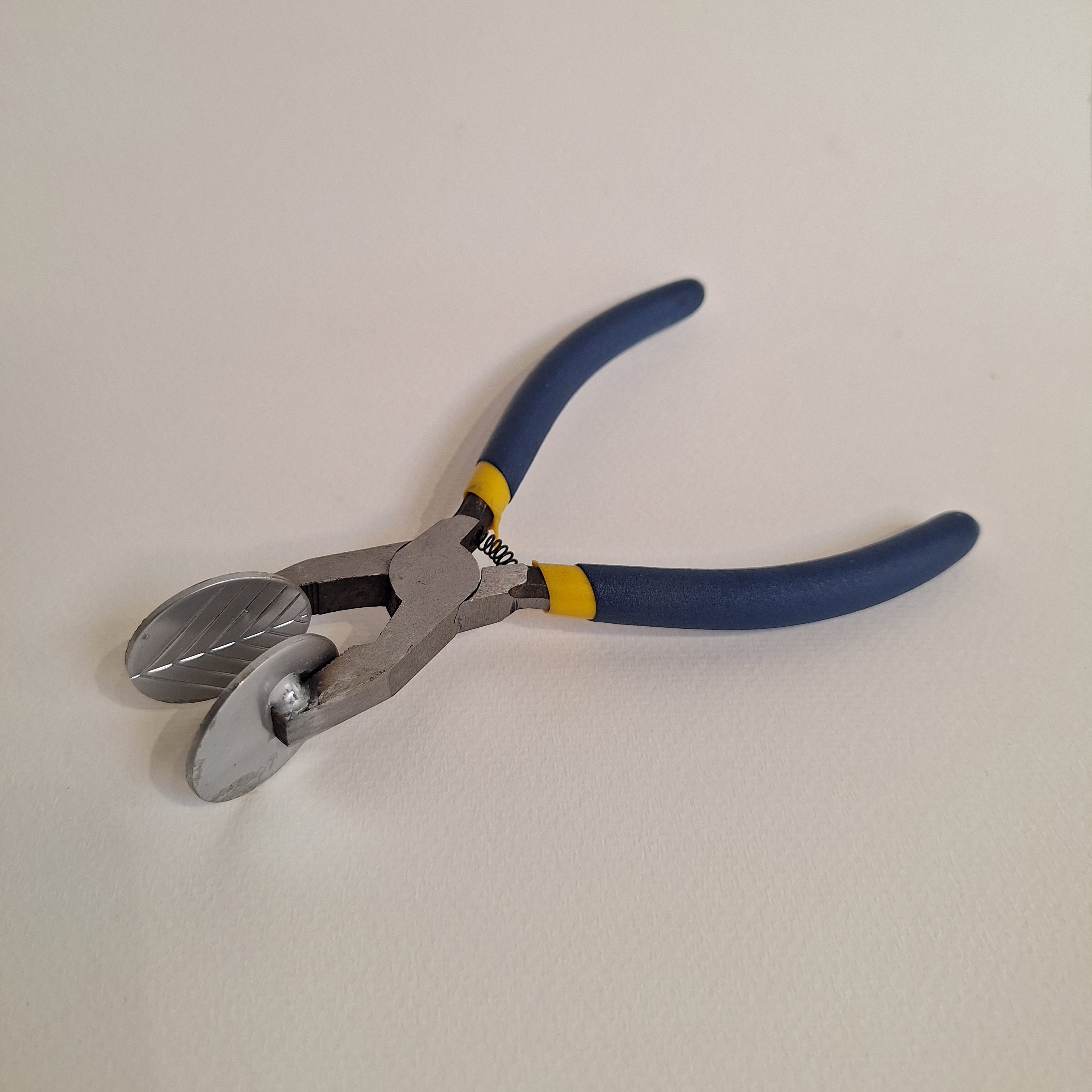 Pair of lampworking mashers with blue handles on a white background